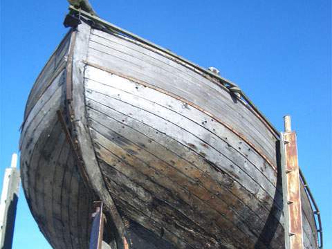 Peenemünder Hafen Nord: Ein altes Fischerboot ist aufgebockt und wartet auf seine Restaurierung.