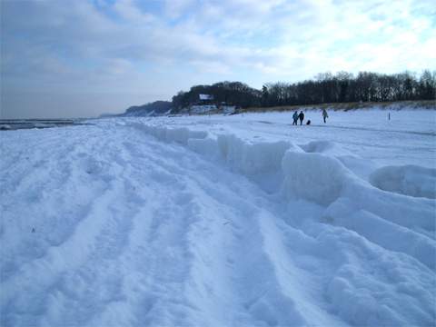 Wellen im Eis auf dem Strand.
