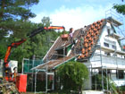 Das fertiggestellte Haus Steinbock, Kran legt die Biberschwänze auf.