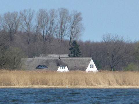 Lütow auf der Insel Usedom: Die schilfgedeckten Häser blicken auf das Achterwasser.